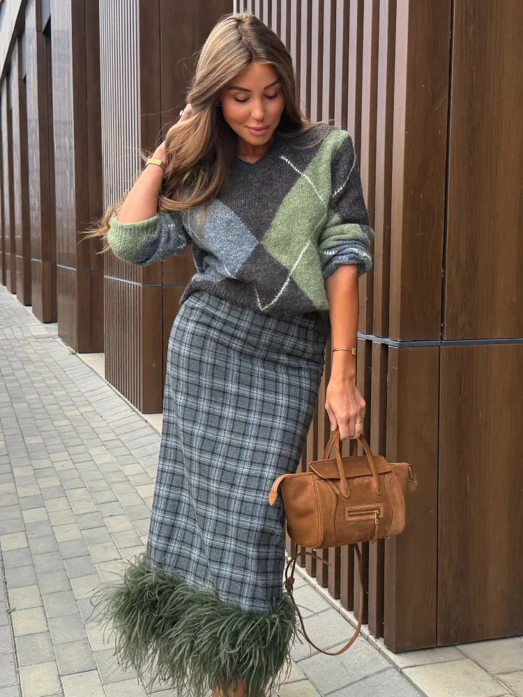 Completo da donna composto da maglione a maglia con motivo a rombi e gonna midi a quadri, con bordo in pelliccia sintetica, ideale per un look casual chic, perfetto per l’autunno…